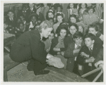 Glass Center - Jacqueline Cochran showing children fragment from America's first glass factory