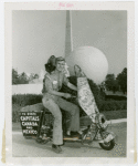 Nels Holmes on scooter with monkey