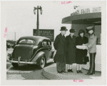 Information Booths - Attentant giving information to man and two women in front of booth shaped like Perisphere