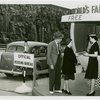 Information Booths - Attendant giving information to first out-of-town visitors at booth shaped like Perisphere outside of Holland Tunnel