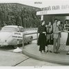Information Booths - Attendant helping man and women at booth shaped like Perisphere outside of Holland Tunnel