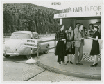 Information Booths - Attendant helping man and women at booth shaped like Perisphere outside of Holland Tunnel