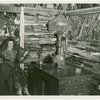 Iraq Participation - Woman in traditional dress in room with textiles and dolls