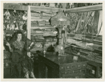 Iraq Participation - Woman in traditional dress in room with textiles and dolls