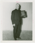 Reverend John H. Lamott holding plaque