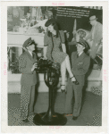 Michigan Participation - Willo Sheridan (Miss Michigan Aviation) - Sitting on top of airplane engine looking down on two pilots