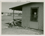 Mosquito protection and control - Man scooping water from under building
