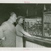 Grover Whalen and Anna Neagle inspecting dollhouse