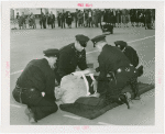 New York City - Police Dept. - Policeman demonstrating giving first aid to victim