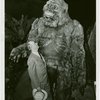 New York Zoological Society - Man standing next to stuffed ape in exhibit