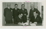 Nicaragua Participation - Noel Ernesto Pallais (Consul General) signs contract, Grover Whalen and group look on
