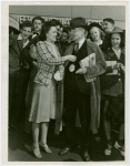 Opening Day - 1940 Season - Woman pinning ""Hello Folks"" label on man