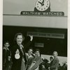 Opening Day - 1940 Season - Woman holding ""Hello Folks"" labels in front of Waltham Watches sign