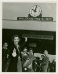 Opening Day - 1940 Season - Woman holding ""Hello Folks"" labels in front of Waltham Watches sign