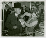 Opening Day - 1940 Season - Woman pinning ""Hello Folks"" label on John Rockefeller