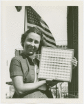 Woman holding Pittsburgh Plate Glass Co. Estimator of Attendance