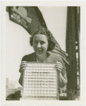 Woman holding Pittsburgh Plate Glass Co. Estimator of Attendance