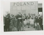 Poland Participation - Official speaking with women in traditional dress before Polish pavilion