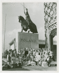 Poland Participation - Witold Wankowicz with women in traditional dress in front of statue