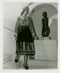 Romania Participation - Woman in traditional dress by statue