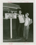 Sports - Two men on roller skates next to sign