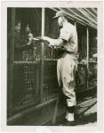 Sports - Baseball - Baseball player passing autograph to boy through fence