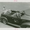 Sports - Ice Skating - Erma Anderson sitting on back of car