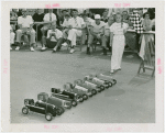 Sports - Midget Car Racing - Girl with checkered flag at starting line of model car race