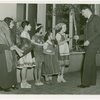 Temple of Religion - Man presenting bibles to children in national costumes