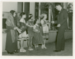 Temple of Religion - Man presenting bibles to children in national costumes