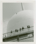 Theme Center - Trylon and Perisphere - Construction - Group watching man in harness painting Perisphere