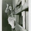 Theme Center - Trylon and Perisphere - Construction - Worker in harness nailing plywood onto Trylon