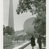 Theme Center - Trylon and Perisphere - View of Trylon and Perisphere with sculpture, fountains, man and woman in foreground