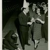 Ticket Sales - Fred Allen selling ticket books to woman and two men while other man lights match from his shoe