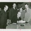 Turkey Participation - Münir Ertegün signing guestbook while others watch