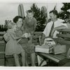 Typical American Family - Family eating hotdogs on bench