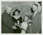 Typical American Family - Arvin family children receiving signed baseball and charm bracelet from Harvey Gibson