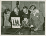 Typical American Family - Burdin family looking through photograph album with Harvey Gibson