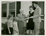 Typical American Family - Cramer family receiving key and lease from Harvey Gibson