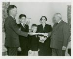 Typical American Family - Filkins family receiving lease and key from Harvey Gibson