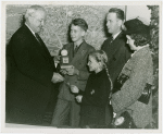 Typical American Family - Hearn family children receiving signed baseball and charm bracelet from Harvey Gibson