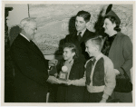 Typical American Family - Karges family children receiving signed baseball and charm bracelet from Harvey Gibson