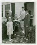 Typical American Family - MacKenzie family receiving key and lease from Harvey Gibson