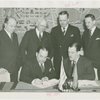 Grover Whalen signing contract with official for Uruguay participation while others look on