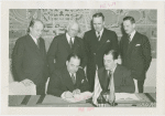 Grover Whalen signing contract with official for Uruguay participation while others look on