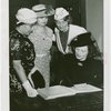 Women's Groups - Anna Neagle signing guestbook while Anna Kross, Bertha McCann and Dorothy Frooks looks on