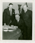 Yugoslavia Participation - Constantin Fotich (Ambassador) signing guestbook while Julius Holmes and Edward Roosevelt look on