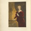 Woman in deep red dress holding a book to her chest, standing next to a table, behind which is a crucifix