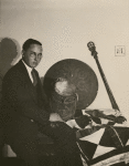 Anthropologist Melville Herskovits with drum, surrounded by other Saramakan objects from Surinam