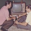 Jack Kerouac and friend with beers next to television; "Life without travel is only half living" [verso]